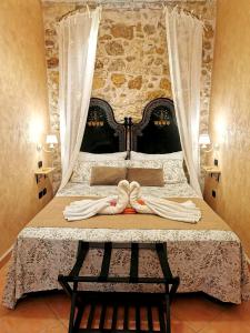 a bedroom with a bed with two towels on it at Home Kitó Ortigia in Siracusa