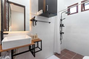 努沙杜瓦的住宿－SUNNYRENT. Green villa for family rest in Nusa Dua，浴室配有白色水槽和淋浴。