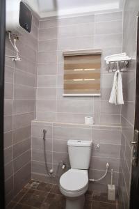 a small bathroom with a toilet and a window at Newly Built 2 Bedroom Tastefully Furnished House Available For Shortlet. in Lagos
