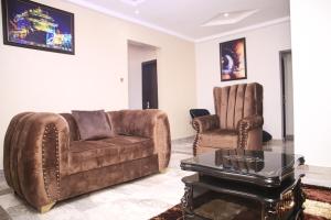 a living room with a couch and a chair at Newly Built 2 Bedroom Tastefully Furnished House Available For Shortlet. in Lagos