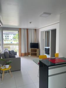 ein Wohnzimmer mit einem Sofa und einem Tisch in der Unterkunft Flat beach class muro alto in Porto De Galinhas