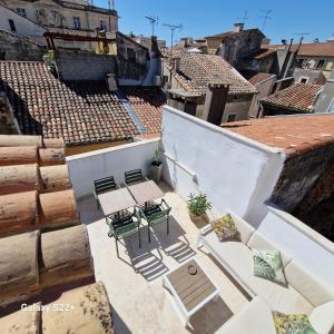un patio al aire libre con sillas y mesas en un edificio en The Rooftop Arles - Terrasse panoramique, en Arles