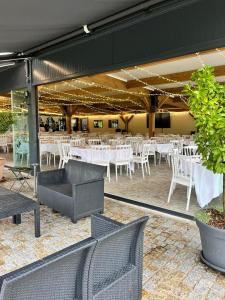 a banquet hall with white tables and white chairs at ORANGERIE de CHATEL-Selection FIGARO & ELLE Magazine in Cleppé