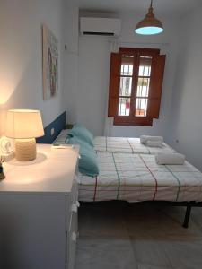 a bedroom with two beds and a desk with a lamp at Apartamento Dueñas in Seville