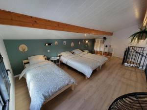 two beds in a room with green walls and wooden floors at Les Cabanes de l'Airial Ecume in Andernos-les-Bains