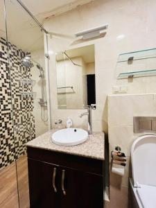 une salle de bain avec un lavabo et une douche dans l'établissement Modern Apartment +Balcony next to Republic Square, City Center, à Erevan