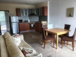 a kitchen with a couch and a table with chairs at Sea Paradise Apartment Complex in Kavarna