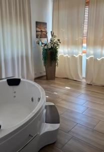 ein Bad mit einer weißen Badewanne in einem Zimmer in der Unterkunft Villa Cresto in Gaglianico