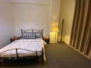 a bedroom with a bed and a lamp in it at The 1st Night Hotel in Amman