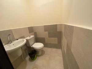 La salle de bains est pourvue de toilettes et d'un lavabo. dans l'établissement The 1st Night Hotel, à Amman