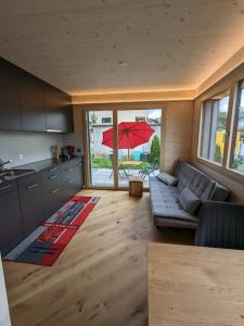 a living room with a couch and an umbrella at TinyHouse - (D)ein Ferienhaus in Schellenberg