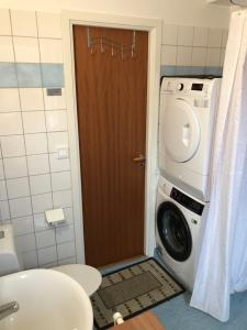 a bathroom with a washing machine and a washer at Nära till allt i Ystad in Ystad