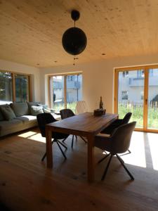 uma sala de estar com uma mesa de madeira e cadeiras em Stylische Fewo in Bestlage in neugebautem Holzhaus mit Oberstaufen Plus em Oberstaufen