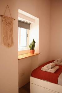 a small bedroom with a bed and a window at Cozy Townhouse With Patio in Raposeira