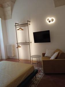 a room with a bed and a couch and a tv at Civico 17 in Lecce