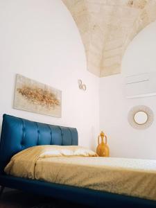 a blue bed in a white bedroom with a ceiling at Civico 17 in Lecce