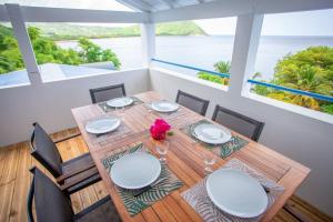 a dining room with a table and chairs and the ocean at Vwe moun Bay in Deshaies