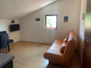 a living room with a leather couch and a window at Villa Una Apartments in Labin