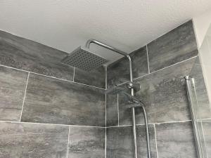 a shower with a shower head in a bathroom at 2 Bedroom Flat, Free Parking & Wi-Fi in Haversham