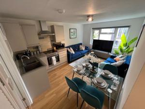 2 Bedroom Flat, Free Parking & Wi-Fi في Haversham: مطبخ وغرفة معيشة مع طاولة وكراسي