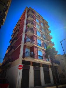 a tall building with a palm tree in front of it at The House of the Waves in Brindisi