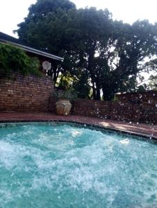 a large pool of water in front of a brick wall at Amaroks self catering units in Sabie