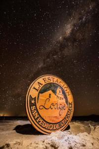 a sign with the name of a la lode on a starry night at Nueva Lodge Estación San Pedro de Atacama in San Pedro de Atacama