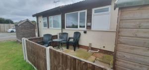 a patio with four chairs and a table on a fence at Jans chalet south shore Bridlington in Bessingby
