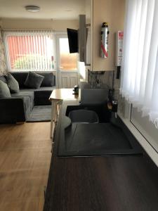 a living room with a couch and a table at Jans chalet south shore Bridlington in Bessingby