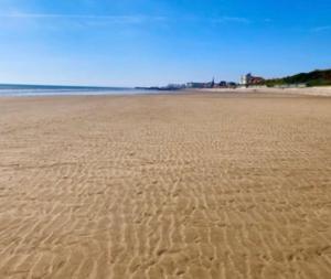 a sandy beach with footprints in the sand at Jans chalet south shore Bridlington in Bessingby