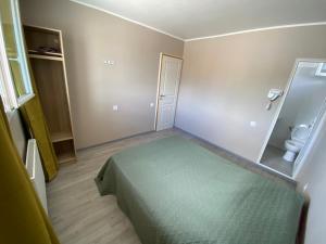 1 dormitorio con cama verde y aseo en Maison OK riba Aéroport Mérignac, en Mérignac