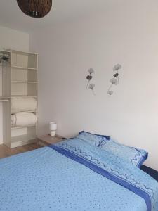 een slaapkamer met een blauw bed en een blauw dekbed bij Appartement F4 Le Milena in Saint-Paul-et-Valmalle