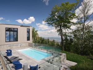 a swimming pool in the backyard of a house at Panorama Charlevoix - Pool, Spa, Exceptional View in Les Éboulements