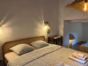 a bedroom with a bed with two pillows and a mirror at La Recampado in Bormes-les-Mimosas