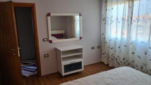 - une petite chambre avec un miroir et un lit dans l'établissement Flavio Apartament Comfort, à Pogradec