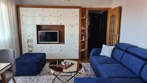 a living room with a blue couch and a tv at Flavio guest house in Pogradec