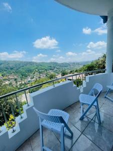 a balcony with chairs and a view of the city at Rusty Bunk Villa in Kandy