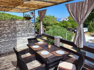 una mesa y sillas en un balcón con vistas en Apartmani Štambuk, en Jelsa