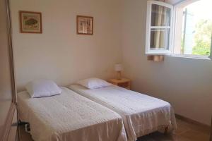 2 camas en una habitación blanca con ventana en Maison Les Marres St-Tropez / Ramatuelle, en Saint-Tropez
