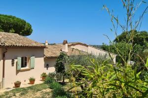 een wit huis met groene luiken en planten bij Maison Les Marres St-Tropez / Ramatuelle in Saint-Tropez