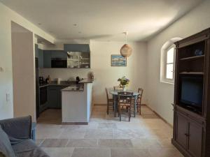 een keuken en woonkamer met een tafel en stoelen bij Maison Les Marres St-Tropez / Ramatuelle in Saint-Tropez