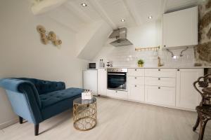 a living room with a blue couch and a kitchen at Casinhas do Miga in Santa Comba Dão