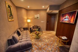 una sala de estar con sofás y una mesa en una habitación en LE PALME HOTEL en Orán