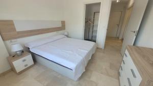 una camera bianca con letto e comodino di Apartamento playa del Albir a Albir