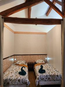 Dos camas en una habitación con dos patos de goma. en Maison 4 couchages, en Ore