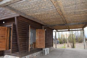 a wooden house with a wooden roof and windows at Cabaña Guadalupe in Tupungato