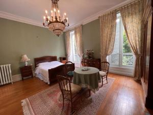 a bedroom with a bed and a table and chairs at LES PAYRATONS in Saint-Gérand-le-Puy