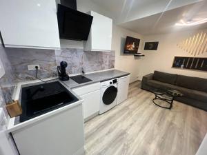 una cucina e un soggiorno con divano in camera di Maison Appartement Triplex avec jacuzzi et sauna a Saint-Étienne