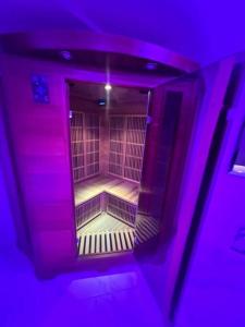 una habitación vacía con luces moradas en un edificio en Maison Appartement Triplex avec jacuzzi et sauna, en Saint-Étienne