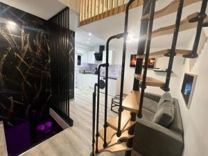een woonkamer met een trap in een huis bij Maison Appartement Triplex avec jacuzzi et sauna in Saint-Étienne